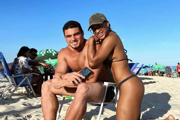 Na imagem colorida, Rebeca Andrade posa em praia ao lado do ex-namorado, Luiz Cleiton. Os dois sorriem- Metrópoles