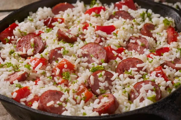 Foto colorida de um arroz com linguiça e vários temperos, receita bem gostosa e fácil de fazer - Metrópoles