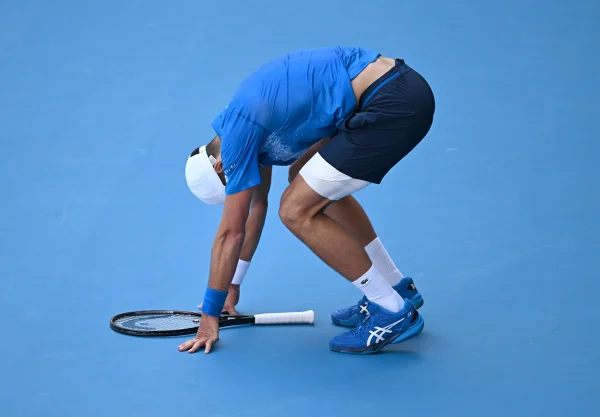 Imagem colorida de Novak Djokovic agachado - Metrópoles