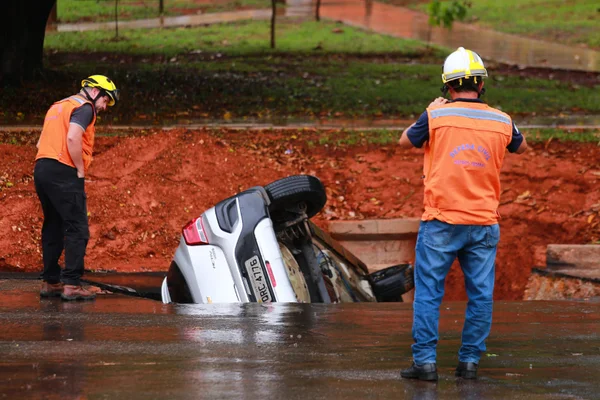 Dona de carro “engolido” por cratera estacionou para fazer compras