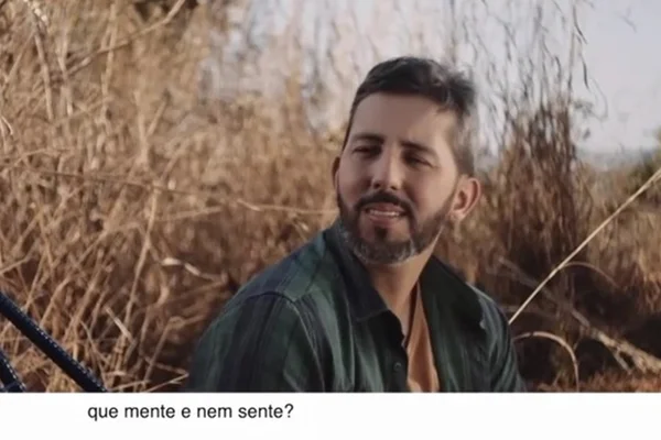Homem com barba em frente a matagal