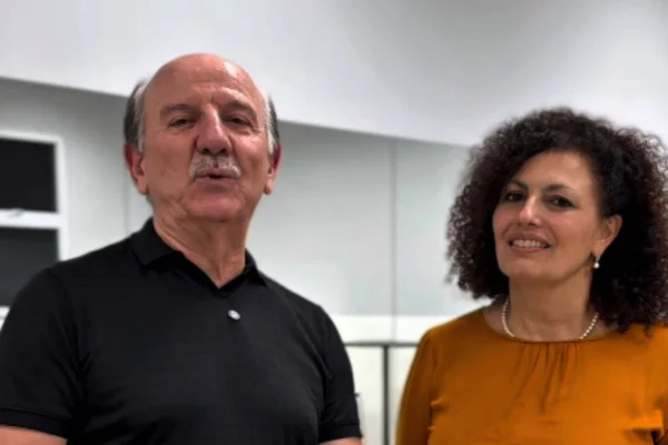 Imagens coloridas mostram homem branco, de bigode, calvo, vestindo camiseta preta, à esquerda, ao lado de mulher branca, cabelos encaracolados, sorrindo, vestindo blusa em tom laranja