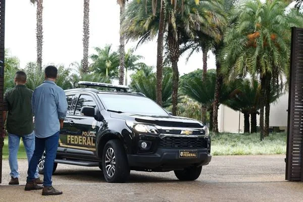 Polícia Federal deixa residência do governador afastado do DF, Ibaneis Rocha, após cerca de 2h30min de buscas. Na imagem, duas viaturas aparecem estacionadas no portão - Metrópoles
