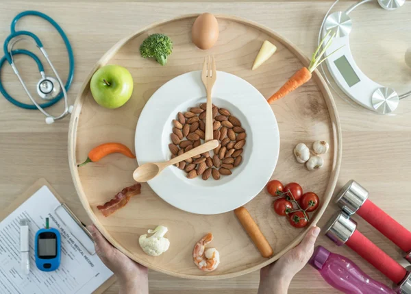 Prato em formato de relógio e aparelho para controle da diabetes ao lado - Metrópoles