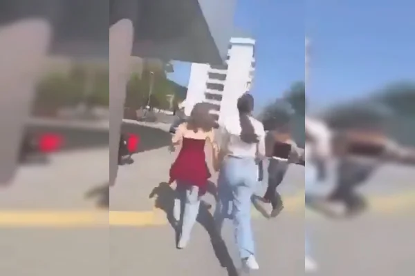 Imagem colorida de alunas correndo de tiroteio