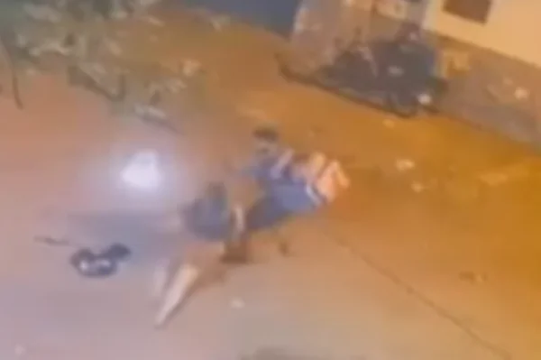 Imagem colorida de uma câmera de segurança mostra um homem e uma mulher brigando em uma rua - Metrópoles