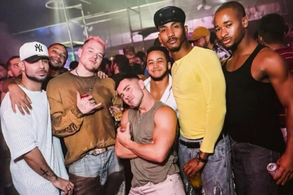 foto colorida de vários homens posando em festa - metrópoles