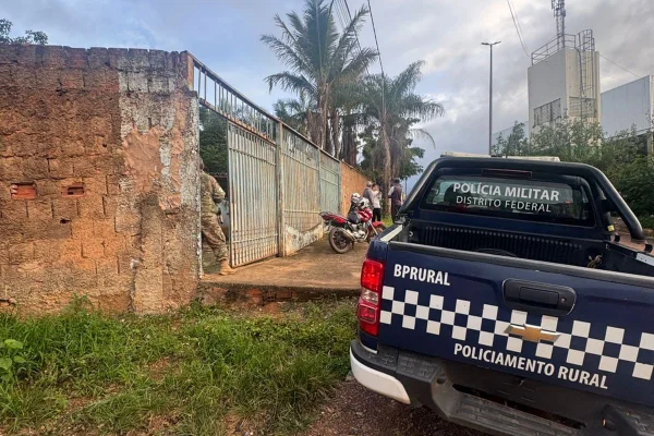 Carro da policia militar em frente a uma casa