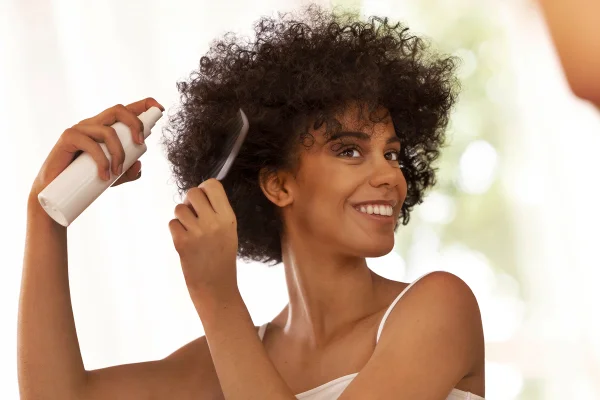 Foto colorida de mulher penteando cabelo