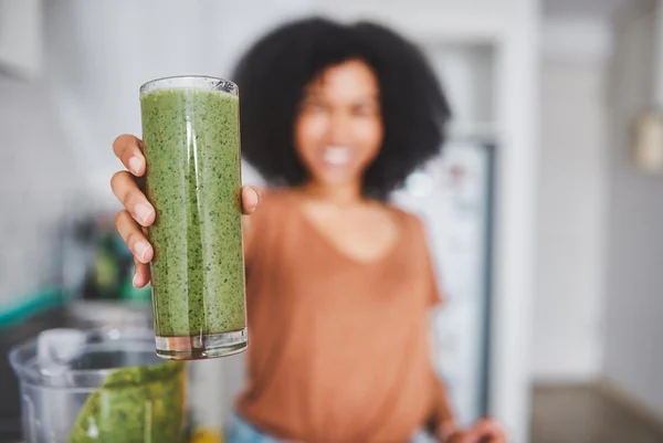 Imagem colorida de mulher segurando uma vitamina verde - Metrópoles