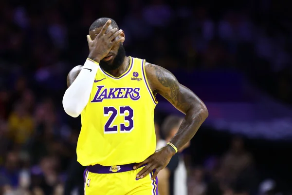 Imagem colorida de LeBron James com a mão no rosto - Metrópoles