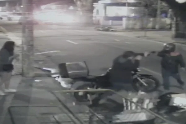 imagens em preto e branco de câmera de segurança mostram ladrão em motocicleta atirando em major da FAB durante assalto na Vila Olimpia - Metrópoles