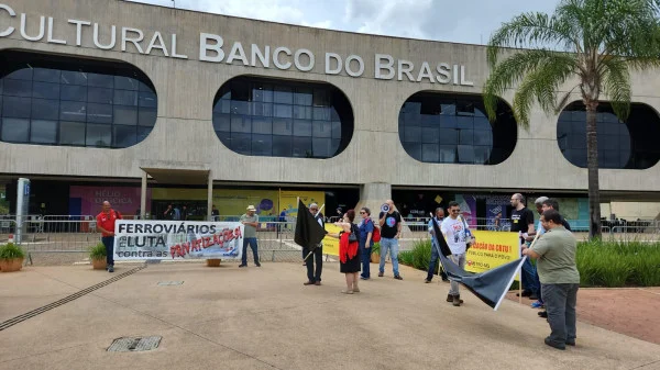 Foto colorida mostra manifestantes com faixas contra a privatização da CBTU-MG, em frente ao CCBB, sede da transição - Metrópoles