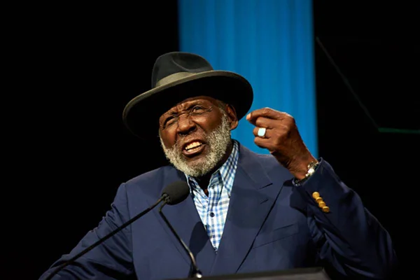 Foto colorida de Richard Roundtree usando terno e chapéu - metrópoles