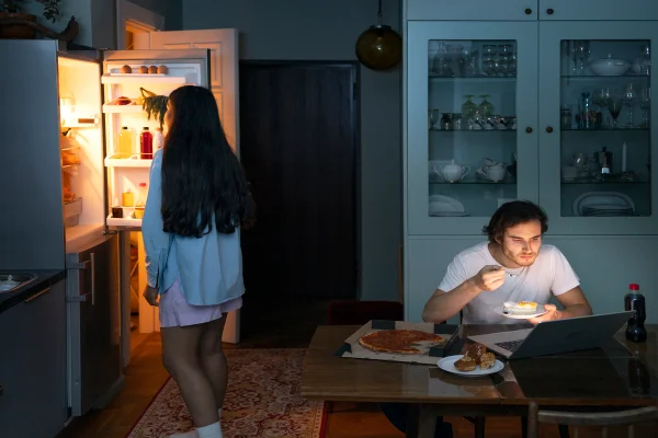 Casal comendo à noite e prejudicando o metabolismo