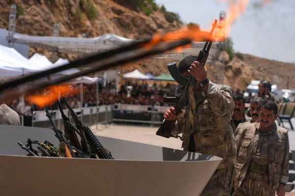 Imagem colorida mostra combatente do PKK queimando arma - Metrópoles