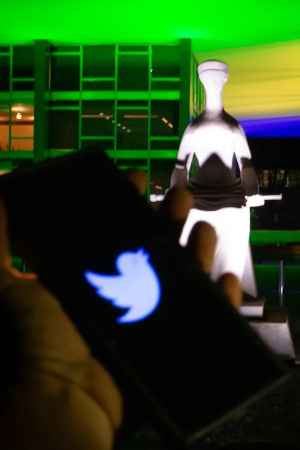 Celular com imagens do site e logo do Twitter em frente ao STF -- Metrópoles