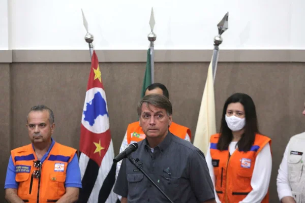 Bolsonaro (PL) discursa em auditório na cidade de Francisco Morato, um dos municípios atingidos pelas chuvas em São Paulo. Ele usa camisa social escura e fala num microfone - Metrópoles