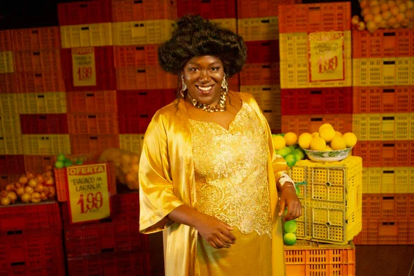 foto colorida de mulher negra de vestido amarelo sorrindo - metrópoles