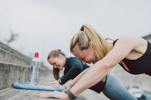 duas meninas fazendo flexão na escada
