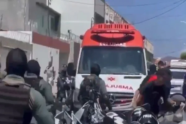 Imagem colorida de policiais e ambulância