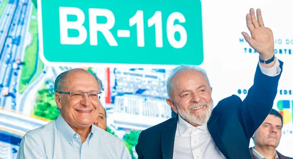 Imagem colorida mostra Lula e Alckmin acenado para plateia em São Paulo- Metrópoles