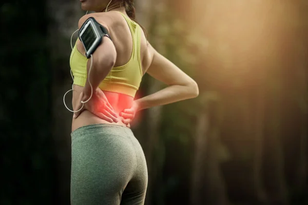 foto colorida mulher com dores no quadril e lombar, buscando exercício para fortalecer região