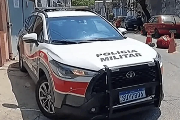 Imagem colorida de viatura da Polícia Militar ao lado de corpo de homem encontrado no meio de rua na zona sul de SP - Metrópoles