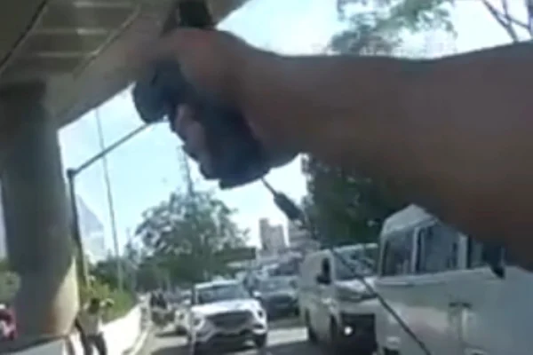 Imagem colorida de PM armado abordando fugitivo. Metrópoles