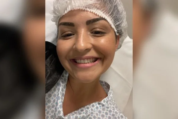 Poliana no dia da cirurgia, com touca e avental do centro cirúrgico