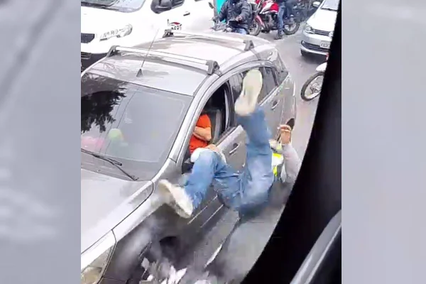 Frame de vídeo mostra motociclista caindo de moto após ser flagrado assaltando motoristas em SP - Metrópoles