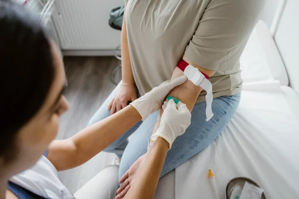 Foto colorida de enfeirmeira tirando sangue de paciente - Médicos explicam quais exames fazer para o check-up anual de saúde - Metrópoles