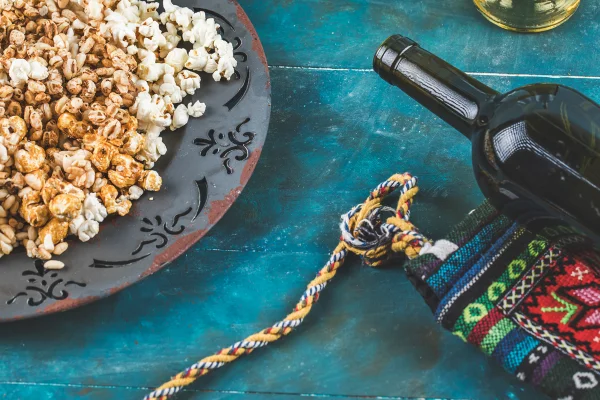 Foto colorida de garrafa de vinho e pipoca