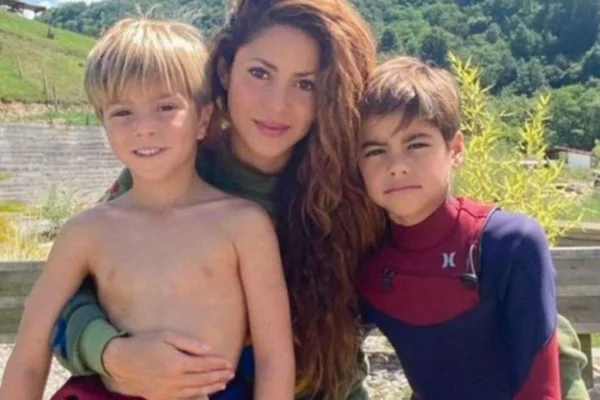 Foto colorida mostra mulher morena abraçada com dois meninos pequenos - Metrópoles