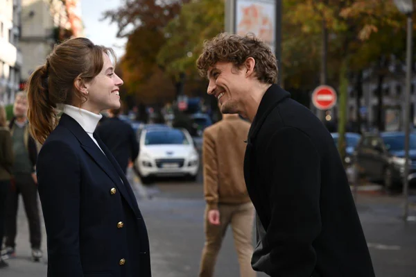 foto colorida de homem e mulher sorrindo enquanto conversam em rua movimentada - metrópoles