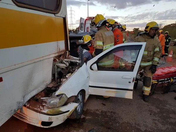 Homem fica preso às ferragens após batida entre carro e ônibus escolar