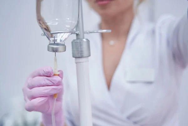 Imagem colorida: enfermeira prepara medicamento para infusão - Metrópoles