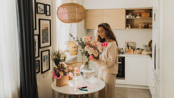 mulher decorando a casa com flores na primavera