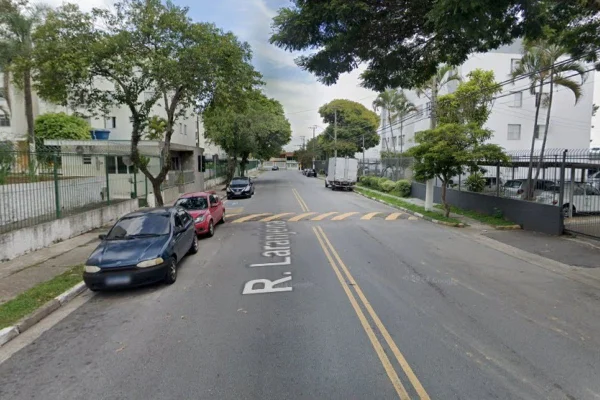 Trecho de rua com dois carros e um caminhão estacionados; algumas árvores compõem a paisagem, onde homem foi assaltado e baleado - Metrópoles
