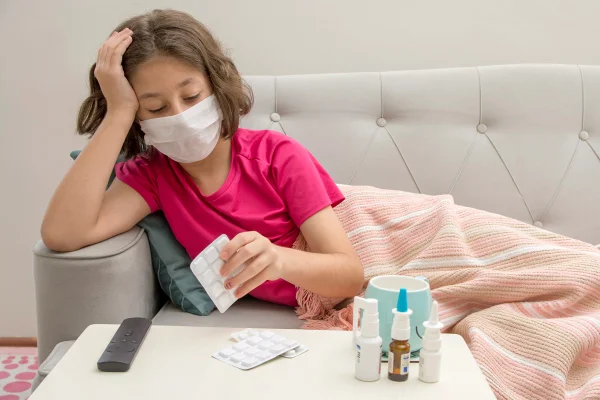 Foto de stock de Uma jovem doente deitada na cama com febre alta. Covid 19 e Foto de estoque de gripe fria covid longa