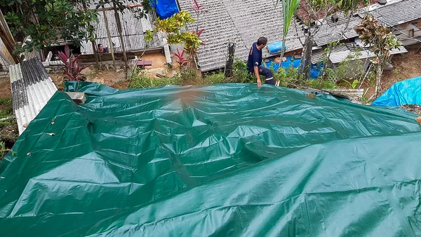 Imagem mostra lona posta em barranco no Litoral Norte de São Paulo chuvas temporal