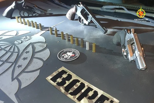Balas em armas em capô de viatura preta do Bope