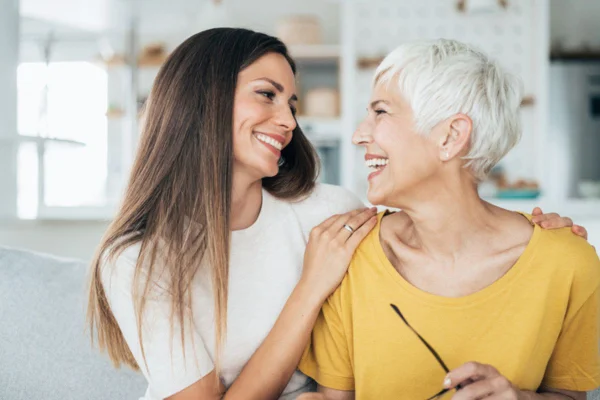 Imagem colorida de mulher conversando com sogra sorrindo