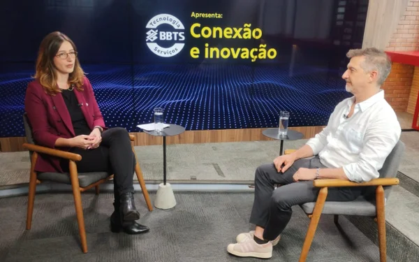 Fotografia colorida mostrando jornalista entrevistando homem em estúdio-Metrópoles