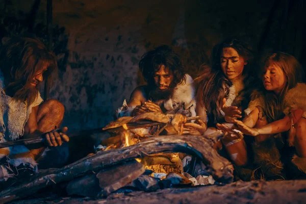 Ilustração de um grupo neandertal, em volta de uma fogueira, preparando o alimento - Metrópoles