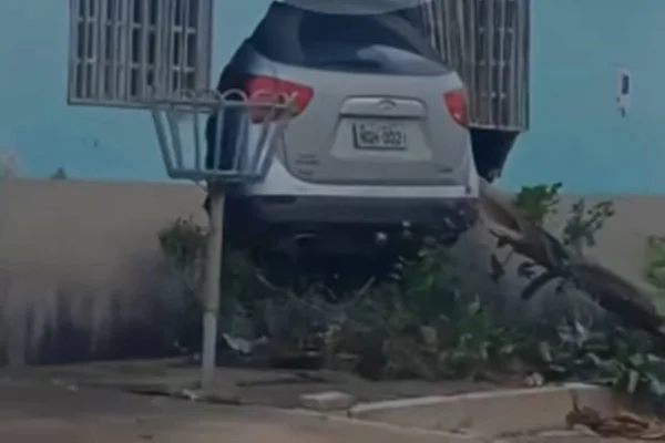 Foto colorida carro atravessado casa