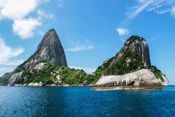 Foto de duas costas de montanhas atrás do mar