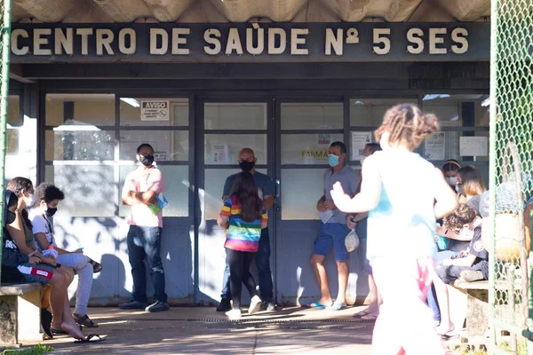 Pessoas em frente a prédio de centro de saúde