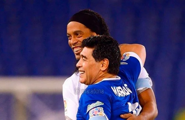 Ronaldinho Gaúcho e Diego Armando Maradona abraçados em jogo festivo