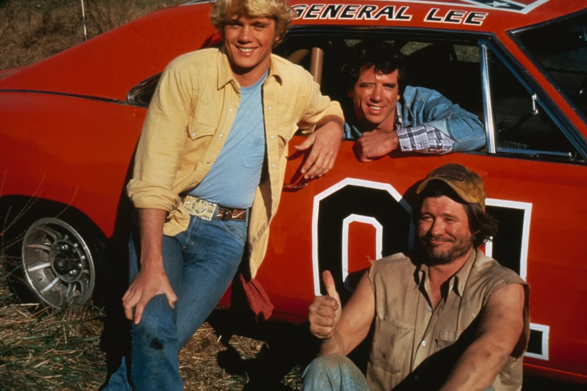 John Schneider, Tom Wopat e Ben Jones como Bo Duke, Luke Duke e Cooter, respectivamente, na série Os Gatões John Schneider, Tom Wopat e Ben Jones como Bo Duke, Luke Duke e Cooter, respectivamente, na série Os Gatões